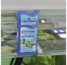JBL Biotopol vattenberedningspreparat för sötvattenakvarier på kanten av ett akvarium.