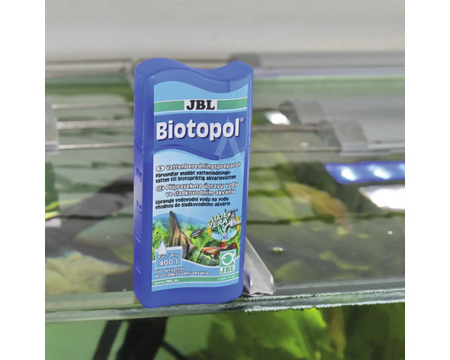 JBL Biotopol vattenberedningspreparat för sötvattenakvarier på kanten av ett akvarium.