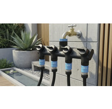 Trädgårdsscen med en for.q multipel fördelare på vattenkranen