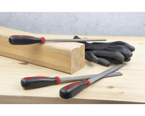 Träblock, handskar och olika filar på en träyta.