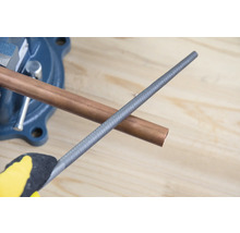 Kopparrör i skruvstäd med metallfil