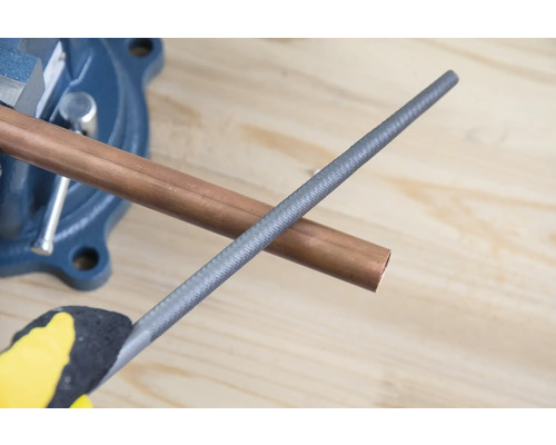 Kopparrör i skruvstäd med metallfil