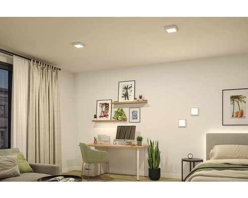 Modernt ljust rum med skrivbord och säng, upplyst av fyrkantiga LED downlights i taket och matchande vägglampor.