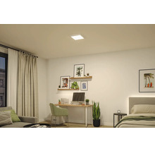 Fyrkantig vit LED-panel i taket i ett modernt rum med skrivbord, vägghyllor och säng.