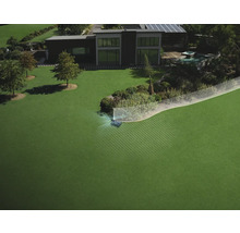 Robotgräsklippare i en stor trädgård med digital visning av navigationssystem och gränser framför ett modernt hus.