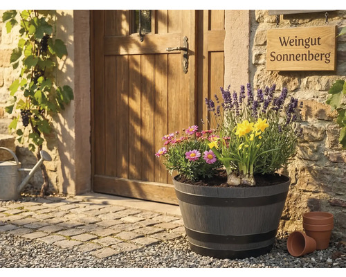 Stort planteringskärl i tunndesign med lavendel, påskliljor och prästkragar framför en rustik trädörr och stenmur.