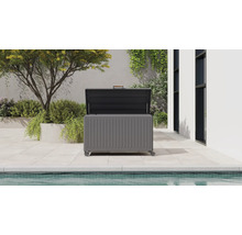 Modern förvaringsbox i metall för trädgården med öppet lock på en ljus terrass intill en pool.