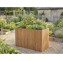 Hög odlingslåda av träribbor med tomater, sallad och örter i en ljus, organiserad trädgård med grusgångar.