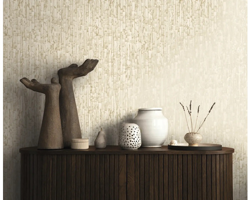 Strukturerad tapet med vertikalt mönster i beige bakom en mörk sideboard med dekorationsobjekt och skulpturer.