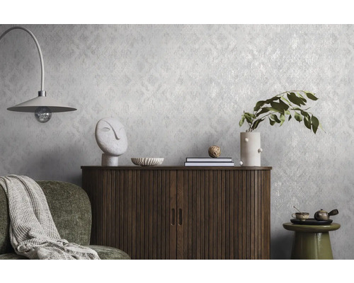 Strukturerad non-woven tapet med diskret mönster på en vägg bakom en träskänk och dekorationer i ett modernt inrett vardagsrum.