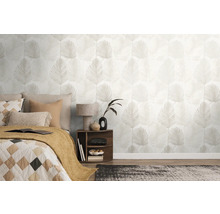 Ljust sovrum med non-woven tapet med palmbladsmönster, en säng med kuddar och ett nattduksbord med lampa.