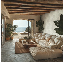 Ljust vardagsrum i medelhavsstil med rustika takbjälkar i trä, naturstensgolv och tapet med bladmotiv.