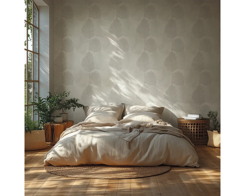 Ljust sovrum med tapet med bladmöster, låg säng med neutrala sängkläder på en rund jutematta och trädetaljer.