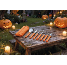Sju delars pumpaslöjdsats med orange handtag och fodral på ett träbord med upplysta Halloweenpumpor och ljus.