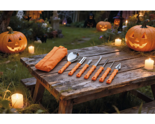 Sju delars pumpaslöjdsats med orange handtag och fodral på ett träbord med upplysta Halloweenpumpor och ljus.