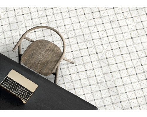 Moderna golvplattor med geometriskt mönster, trästol och mörkt skrivbord med bärbar dator i ett ljust rum.