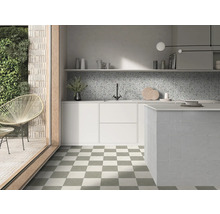 Ljust modernt kök med schackrutiga golvplattor, vita skåp, mönstrat stänkskydd och kaklad köksö.