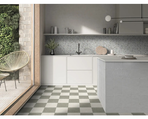 Ljust modernt kök med schackrutiga golvplattor, vita skåp, mönstrat stänkskydd och kaklad köksö.
