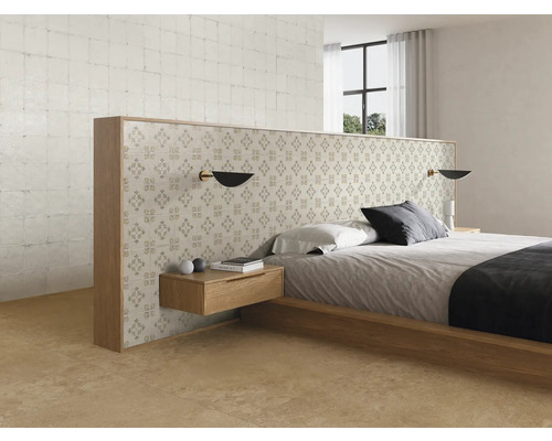 Modernt, ljust sovrum med sängram i trä, skiljevägg med mönstrat kakel, svävande nattduksbord och klinkergolv.