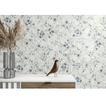 Väggplattor med botaniskt bladmönster i ett ljust rum med glasvas och träfigur på en byrå.