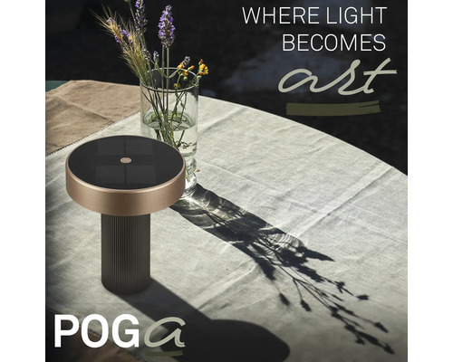 POGA solcellsbordslampa på ett trädgårdsbord med duk bredvid en glasvas med blommor.