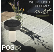 Poga solcellsdriven bordslampa med räfflad fot på ett dukat trädgårdsbord bredvid en blomvas.