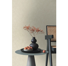 Strukturerad non-woven tapet i beige i ett modernt rum med sidobord, vas med torkade blommor och stol.