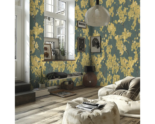 Modernt vardagsrum med non-woven tapet med gula blommotiv på mörk bakgrund, trägolv och ljus saccosäck.