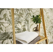 Non-woventapet med botaniskt bladsmönster, med en trähylla, handdukar och en krukväxt.