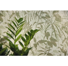 Non-woven tapet med botaniskt bladmotiv och en växt i förgrunden.