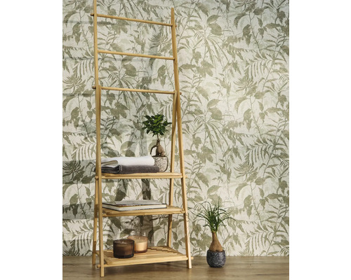 Non-woventapet med botaniskt bladmotiv och fåglar bakom en bambuhylla med handdukar och växter i ett ljust rum.