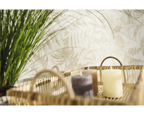 Non-woven tapet med ljust botaniskt bladmöster bakom en dekorativ korg med ljus och grönt gräs.