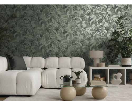 Modernt vardagsrum med botanisk mönstrad tapet, vit modulär soffa och soffbord i glas i en ljus och organiserad miljö.