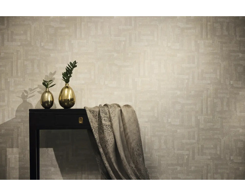 Non-woventapet med abstrakt geometriskt mönster i beige, visad i en modern miljö med mörkt konsolbord och guldvaser.