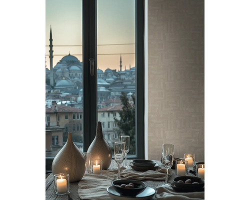 Dukat bord med keramikvaser, tända ljus och glas framför ett fönster med stadsutsikt och beige strukturerad tapet.