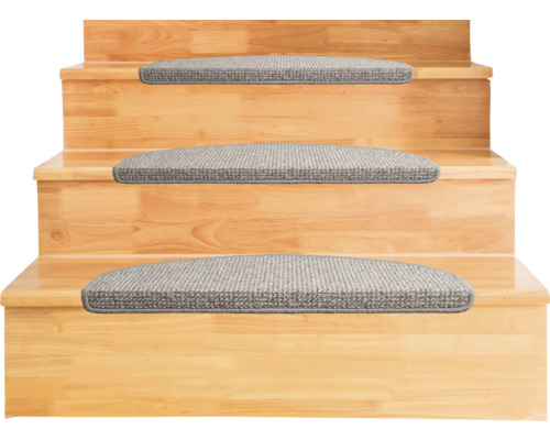 Halvrunda trappstegsmattor av grått textilmaterial på trappsteg av trä.