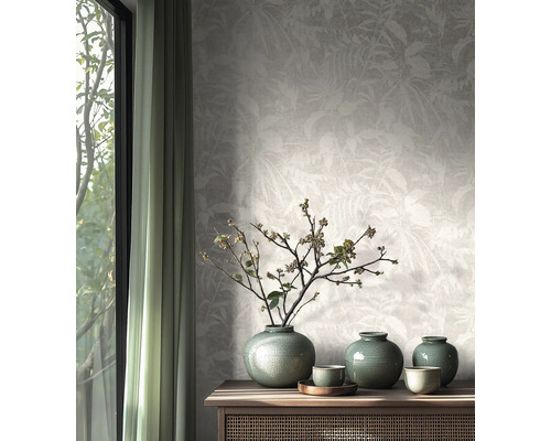 Non-woven tapet med subtilt bladmotiv i ett ljust, naturligt inrett rum med sideboard i trä och keramikvaser.