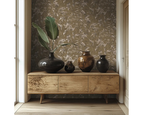 Sideboard i trä framför en vägg med tapet med bladmotiv, dekorerat med olika mörka vaser och stora gröna blad.