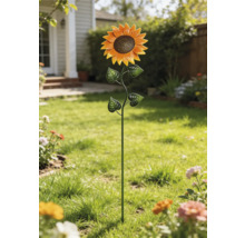 Dekorativ trädgårdspinne i form av en solros av metall på en gräsmatta.