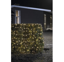 LED-ljusslinga för utomhusbruk i varmvitt, lindad runt en häck, nattetid framför ett modernt hus.