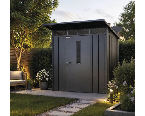 Modernt redskapsskjul i metall med pulpettak, dörr med fönster och överljus i en trädgård med gångplattor och växter.