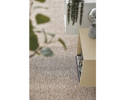 Strukturerad heltäckningsmatta i beige och bruna toner i ett ljust, modernt rum med sidobord och växter.