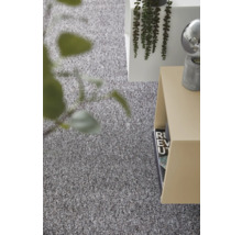Strukturerad grå heltäckningsmatta i ett ljust, modernt inrett rum med sidobord och växt.