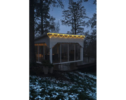 LED-ljusslinga istappar varmvit på en modern friggebod i en vintrig nattmiljö.