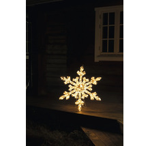 Belyst LED-snöflinga med varmvitt ljus som juldekoration på en träterrass framför ett hus på natten.