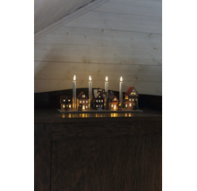 Adventsljusstake i trä med fyra LED-ljus, upplysta miniatyrhus, granar och rensläde.