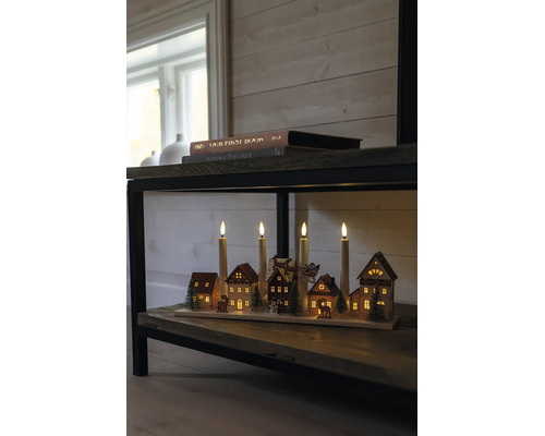 Juldekoration i trä med fyra LED-ljus och en belyst vinterby på en trähylla.