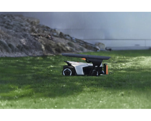 Modernt skyddsgarage för en robotgräsklippare på en gräsmatta vid regn, funktionell design för väderskydd.
