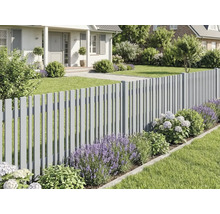 Modernt grått staket i en välskött trädgård med lavendel, hortensior och gräsmatta framför ett hus.