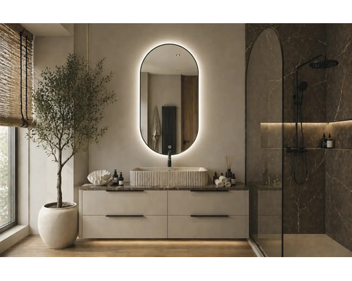 Modernt badrum med oval LED-spegel, räfflat tvättställ, ljust tvättställsskåp och walk-in-dusch med marmorkänsla.
